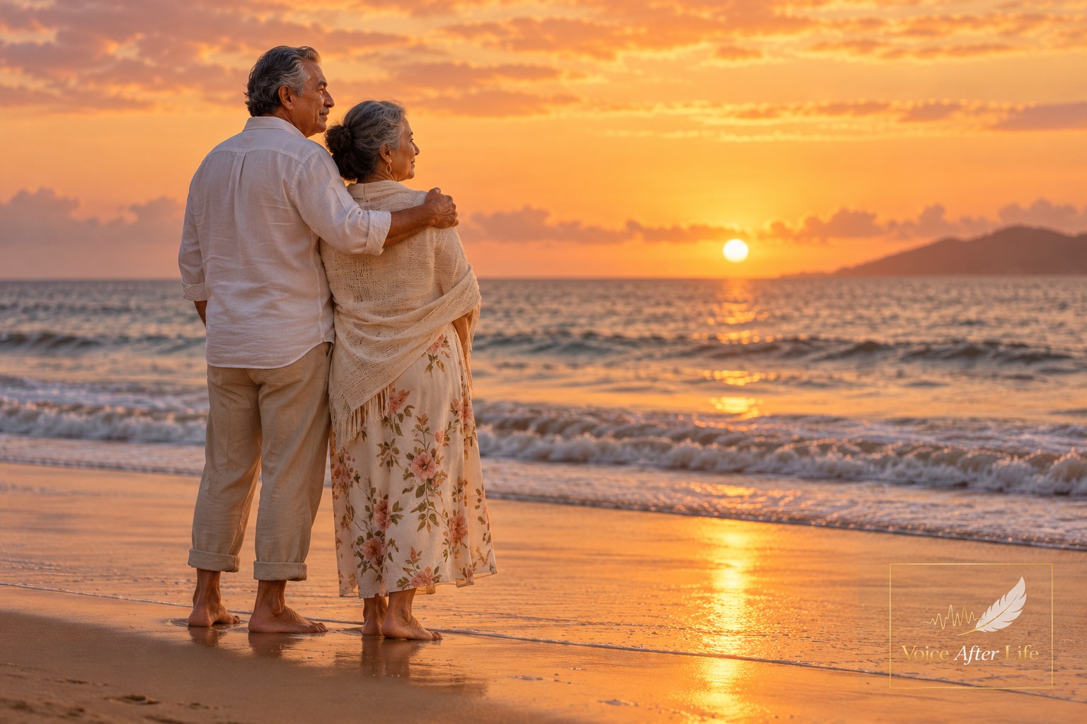 Older South Asian couple stand arm-in-arm at the ocean during sunset, quietly reflecting together.
